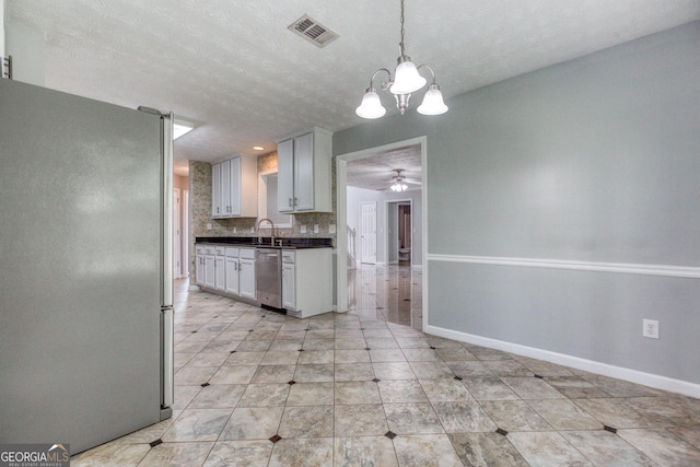 kitchen featuring visible vents, dark countertops, appliances with stainless steel finishes, white cabinetry, and pendant lighting