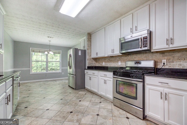 kitchen featuring stainless steel appliances, dark countertops, white cabinets, and tasteful backsplash