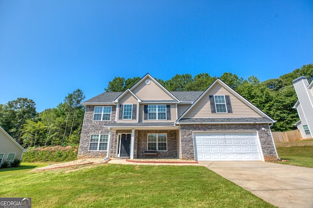 traditional-style home featuring a garage, concrete driveway, stone siding, and a front yard