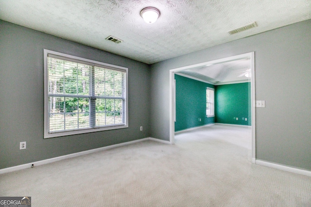 unfurnished room with baseboards, visible vents, and light colored carpet