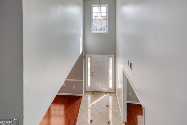 foyer entrance featuring baseboards, visible vents, and wood finished floors