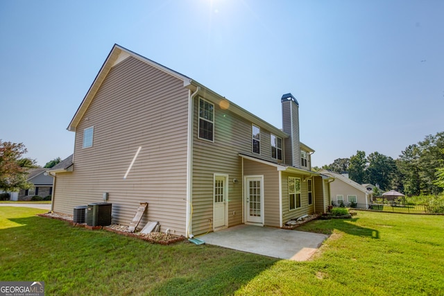 rear view of property featuring fence, a lawn, and a patio