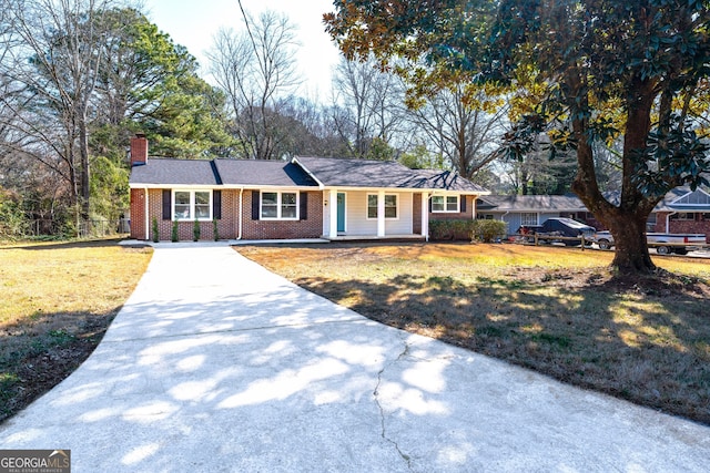 ranch-style house featuring concrete driveway, brick siding, a chimney, and a front lawn