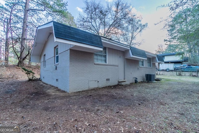 view of property exterior featuring brick siding, roof with shingles, central air condition unit, entry steps, and crawl space