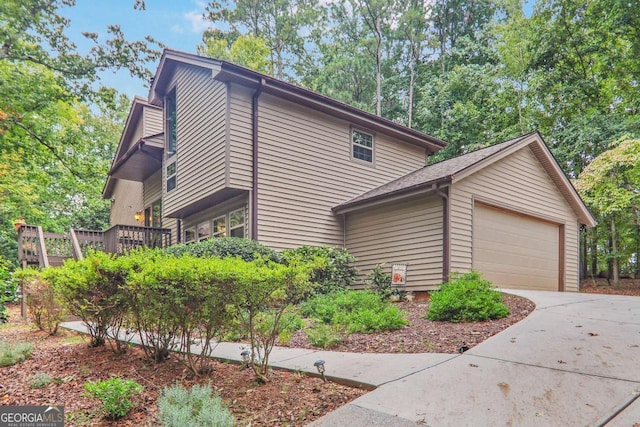 view of property exterior with a garage and concrete driveway