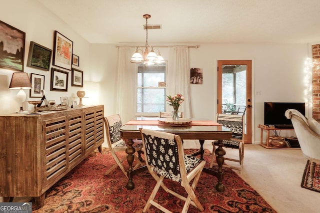 dining area featuring a chandelier, carpet, visible vents, and plenty of natural light