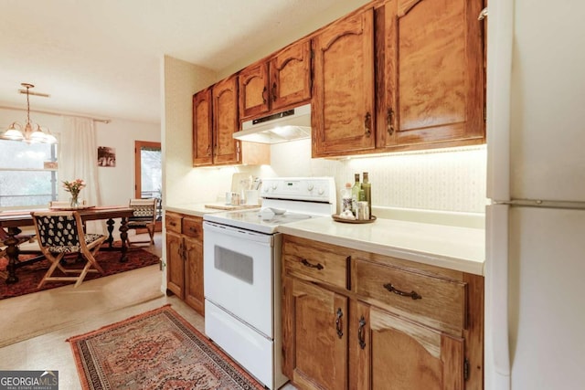 kitchen with pendant lighting, light countertops, brown cabinetry, white appliances, and under cabinet range hood