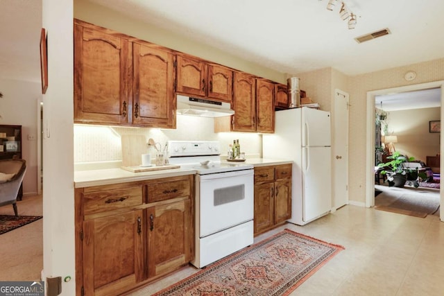 kitchen featuring visible vents, light countertops, brown cabinetry, white appliances, and under cabinet range hood