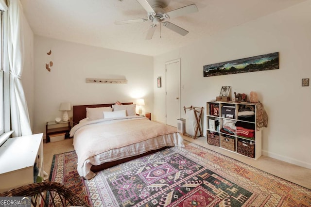 carpeted bedroom with ceiling fan and baseboards