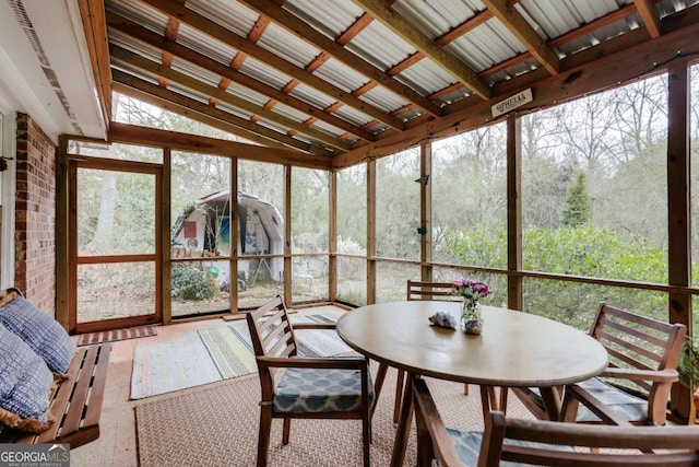 sunroom / solarium with vaulted ceiling and a healthy amount of sunlight