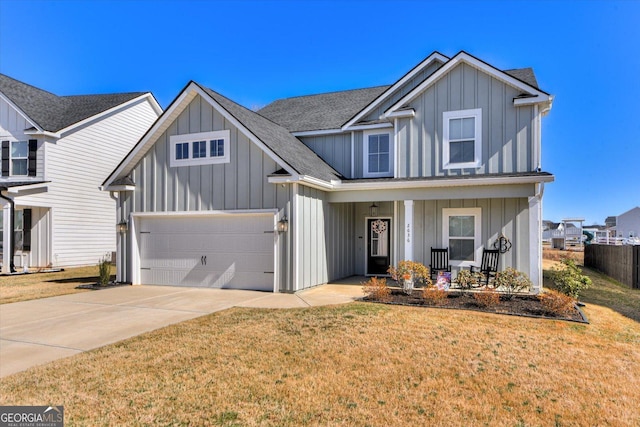 view of front of property with covered porch, a garage, driveway, a front lawn, and board and batten siding