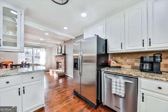 kitchen with white cabinets, stainless steel fridge with ice dispenser, glass insert cabinets, a fireplace, and beam ceiling