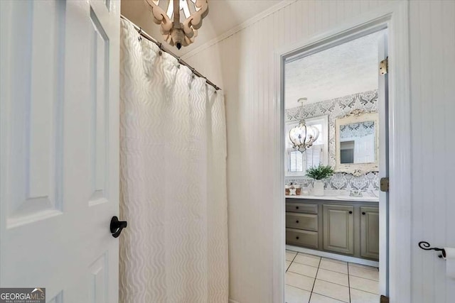 bathroom featuring wallpapered walls, an inviting chandelier, vanity, and tile patterned floors