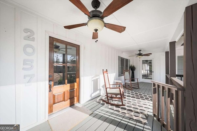 wooden terrace featuring covered porch and a ceiling fan