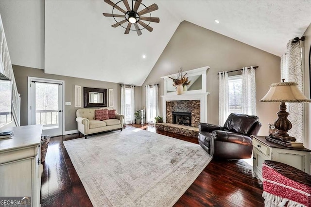 living room with high vaulted ceiling, a fireplace, dark wood finished floors, and baseboards