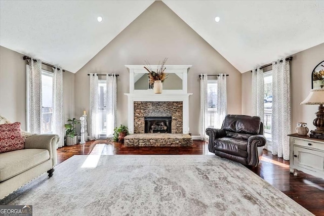 living area featuring dark wood-style floors, a fireplace, and high vaulted ceiling