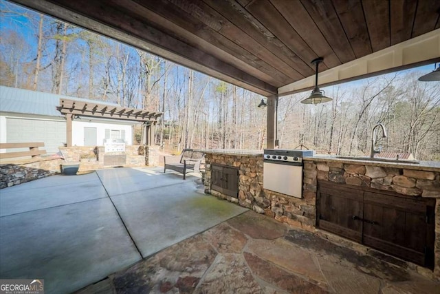 view of patio / terrace featuring exterior kitchen, area for grilling, and a sink