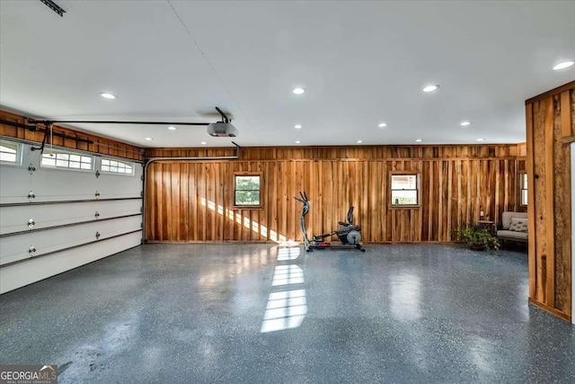 garage featuring a garage door opener, recessed lighting, and wooden walls