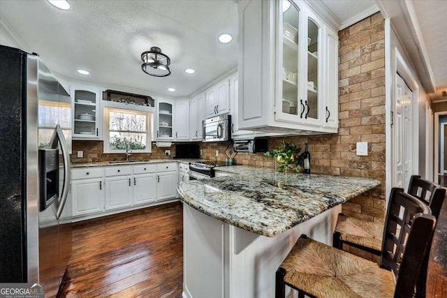 kitchen with stainless steel appliances, white cabinets, and glass insert cabinets