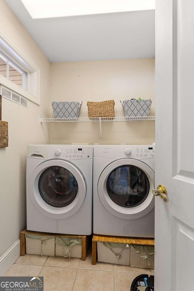 washroom with laundry area, separate washer and dryer, and tile patterned floors