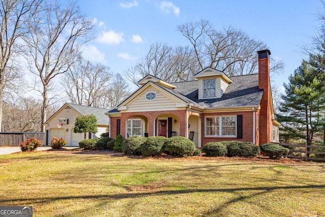 view of front of home featuring a garage, brick siding, fence, a chimney, and a front yard