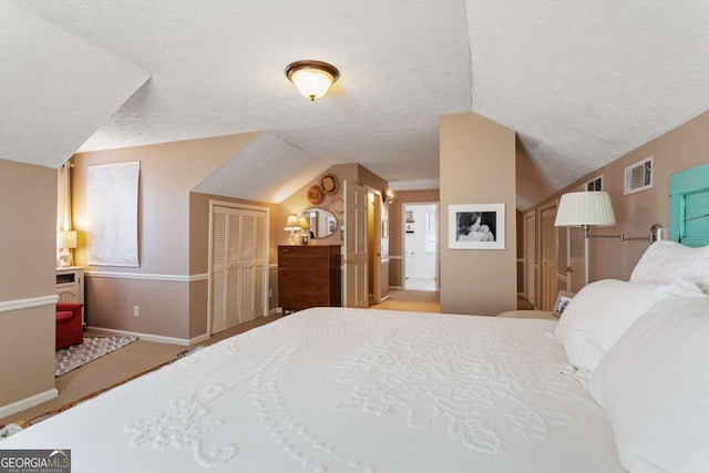 bedroom with a textured ceiling, visible vents, baseboards, vaulted ceiling, and carpet