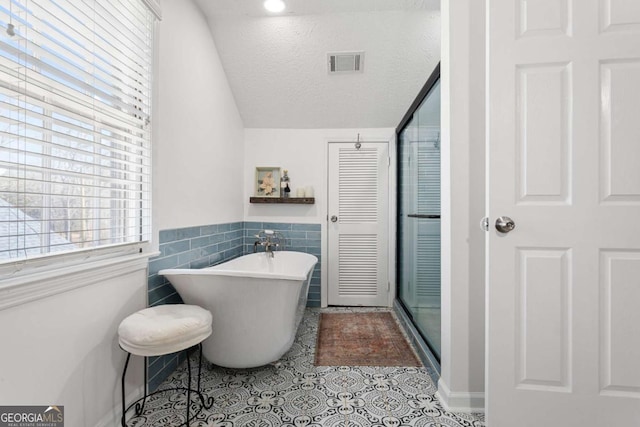 full bathroom featuring visible vents, a soaking tub, tile patterned floors, a textured ceiling, and a shower stall