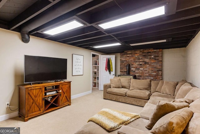 living room featuring a wood stove, baseboards, and light colored carpet