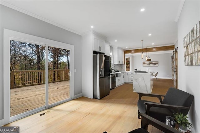 kitchen featuring visible vents, white cabinets, ornamental molding, stainless steel fridge with ice dispenser, and decorative light fixtures