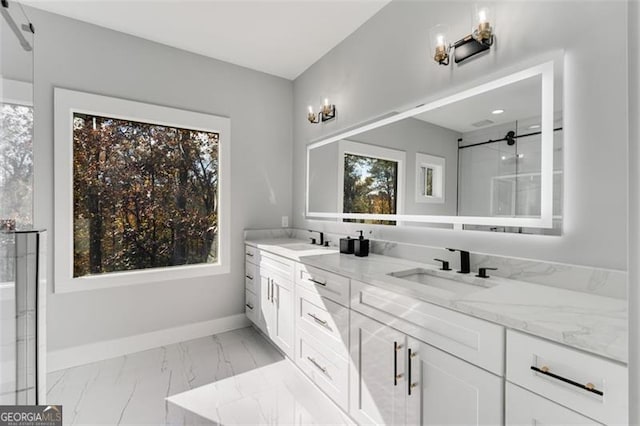 bathroom with plenty of natural light, marble finish floor, a sink, and baseboards