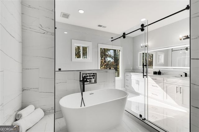 bathroom featuring a soaking tub, visible vents, and marble finish floor