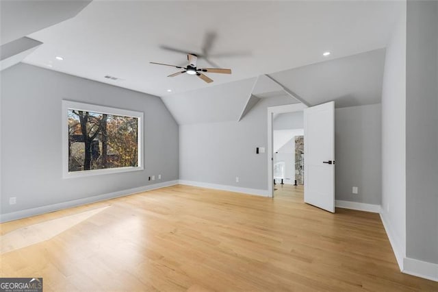 bonus room featuring light wood-type flooring, ceiling fan, baseboards, and lofted ceiling