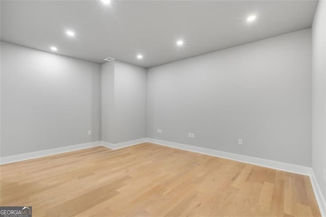 empty room featuring light wood-style floors, visible vents, baseboards, and recessed lighting