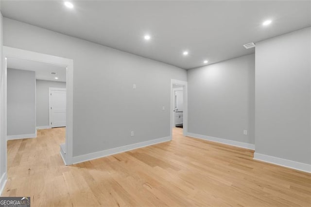 empty room featuring light wood-style floors, baseboards, and recessed lighting