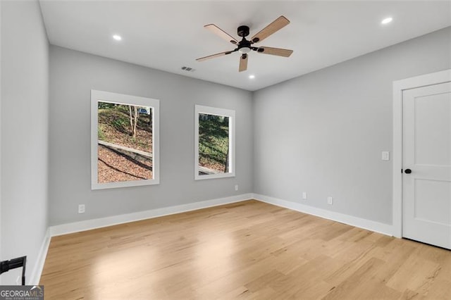 unfurnished room featuring light wood-style flooring, visible vents, baseboards, and a ceiling fan