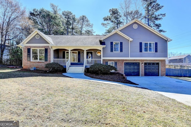 split level home with an attached garage, covered porch, brick siding, concrete driveway, and a front yard