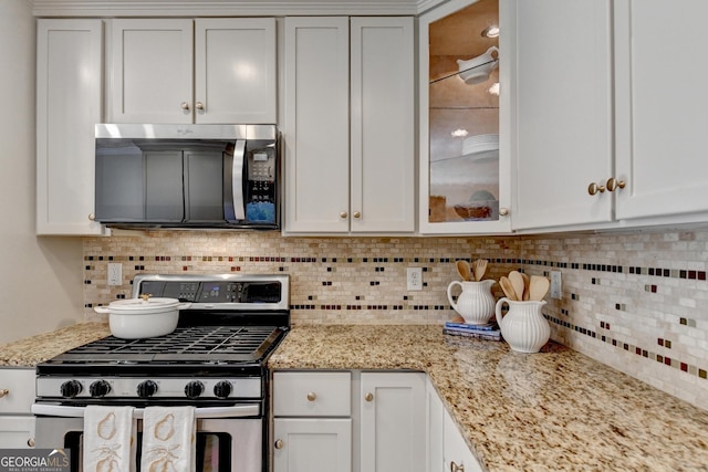 kitchen featuring glass insert cabinets, white cabinetry, and appliances with stainless steel finishes