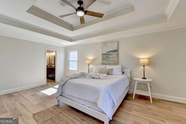 bedroom with light wood-type flooring, a raised ceiling, crown molding, and baseboards