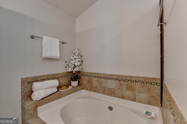 bathroom featuring a garden tub and a textured ceiling