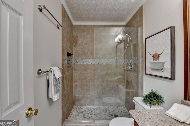 bathroom with toilet, ornamental molding, a tile shower, a textured ceiling, and vanity