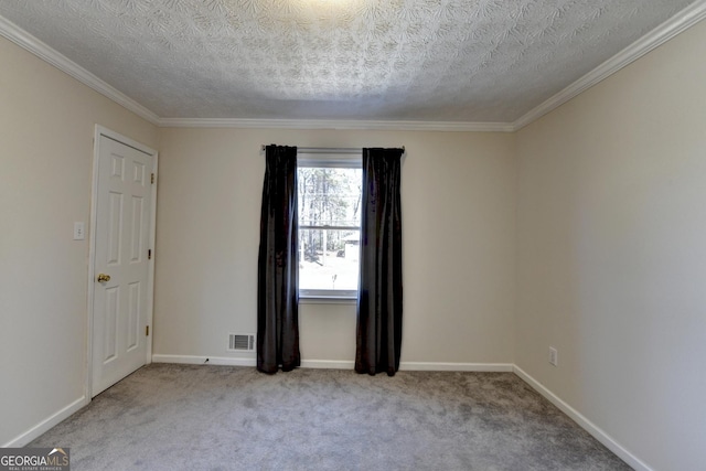 empty room featuring carpet floors, visible vents, a textured ceiling, and baseboards