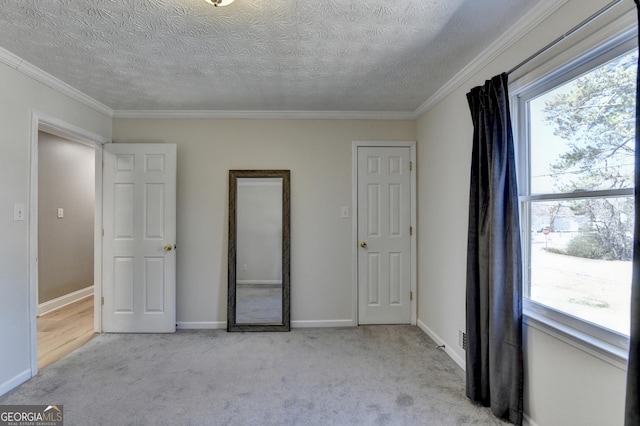 unfurnished bedroom with carpet floors, baseboards, and a textured ceiling