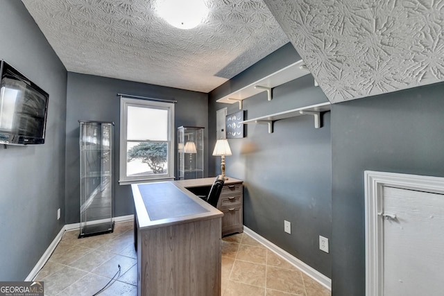 home office with a textured ceiling, baseboards, and light tile patterned floors