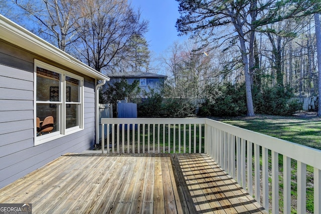 wooden terrace featuring a lawn