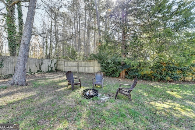 view of yard with an outdoor fire pit and fence