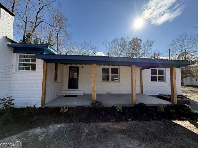 view of front facade featuring covered porch and brick siding