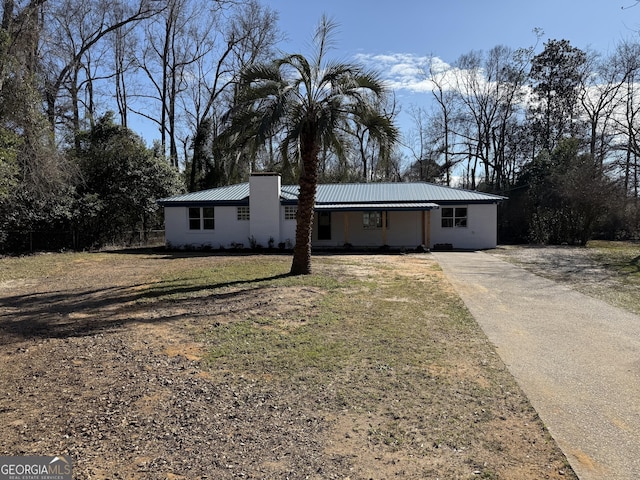 view of front of home with metal roof and a front yard