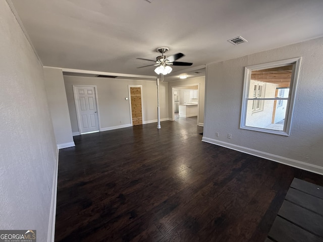 unfurnished living room with baseboards, visible vents, a ceiling fan, and dark wood-type flooring