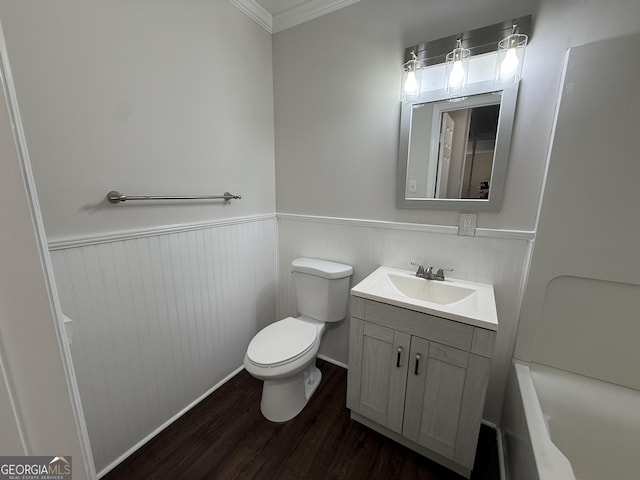 bathroom featuring a wainscoted wall, toilet, ornamental molding, vanity, and wood finished floors