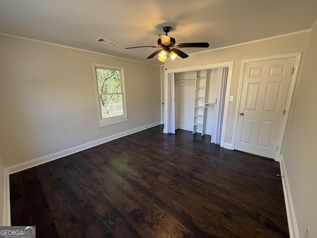 unfurnished bedroom featuring visible vents, baseboards, ornamental molding, a closet, and dark wood finished floors